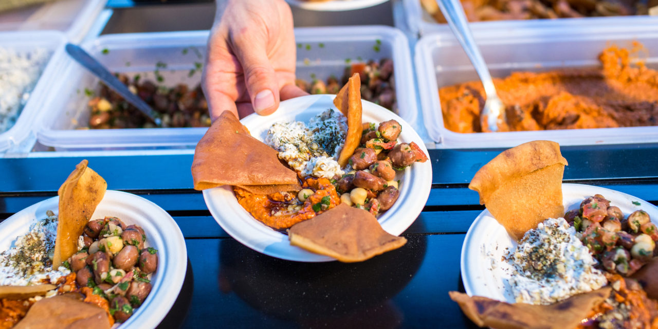 Bufê emprega refugiados para cozinhar a culinária de seu país