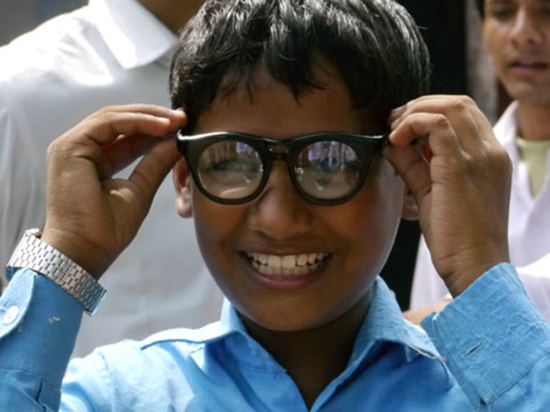 garoto moreno sorrindo colocando óculos