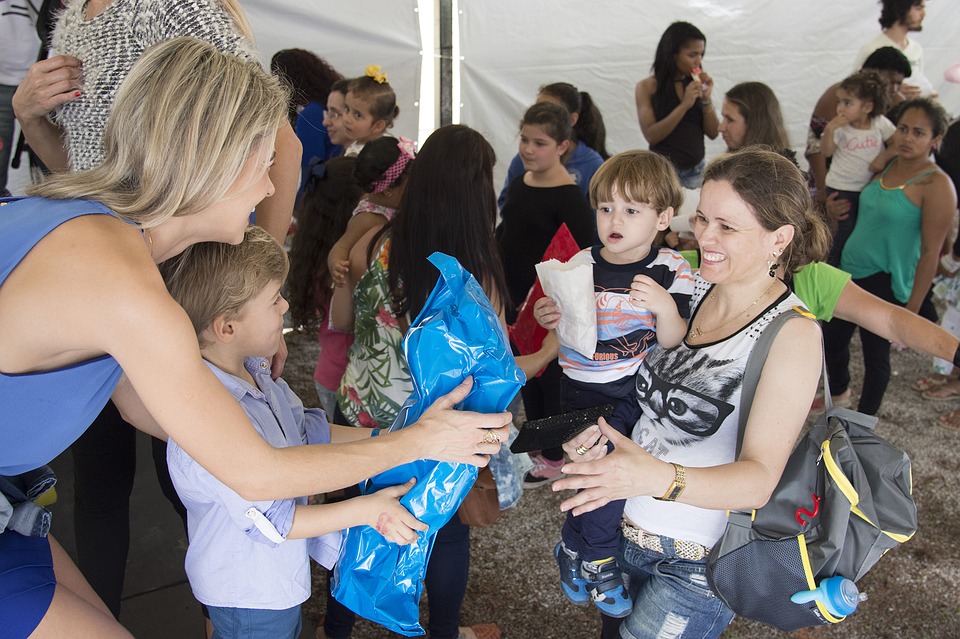 Mulheres dando presentes para crianças em uma tenda