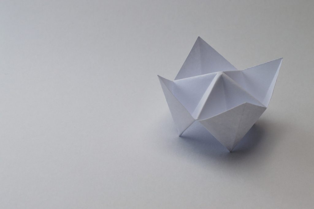 Escultura branca em forma de coroa feita de papel origami 