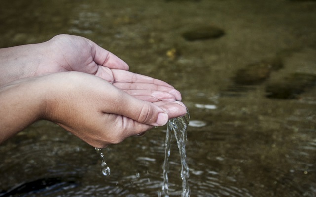 mãos segurando água em rio: fundo de água